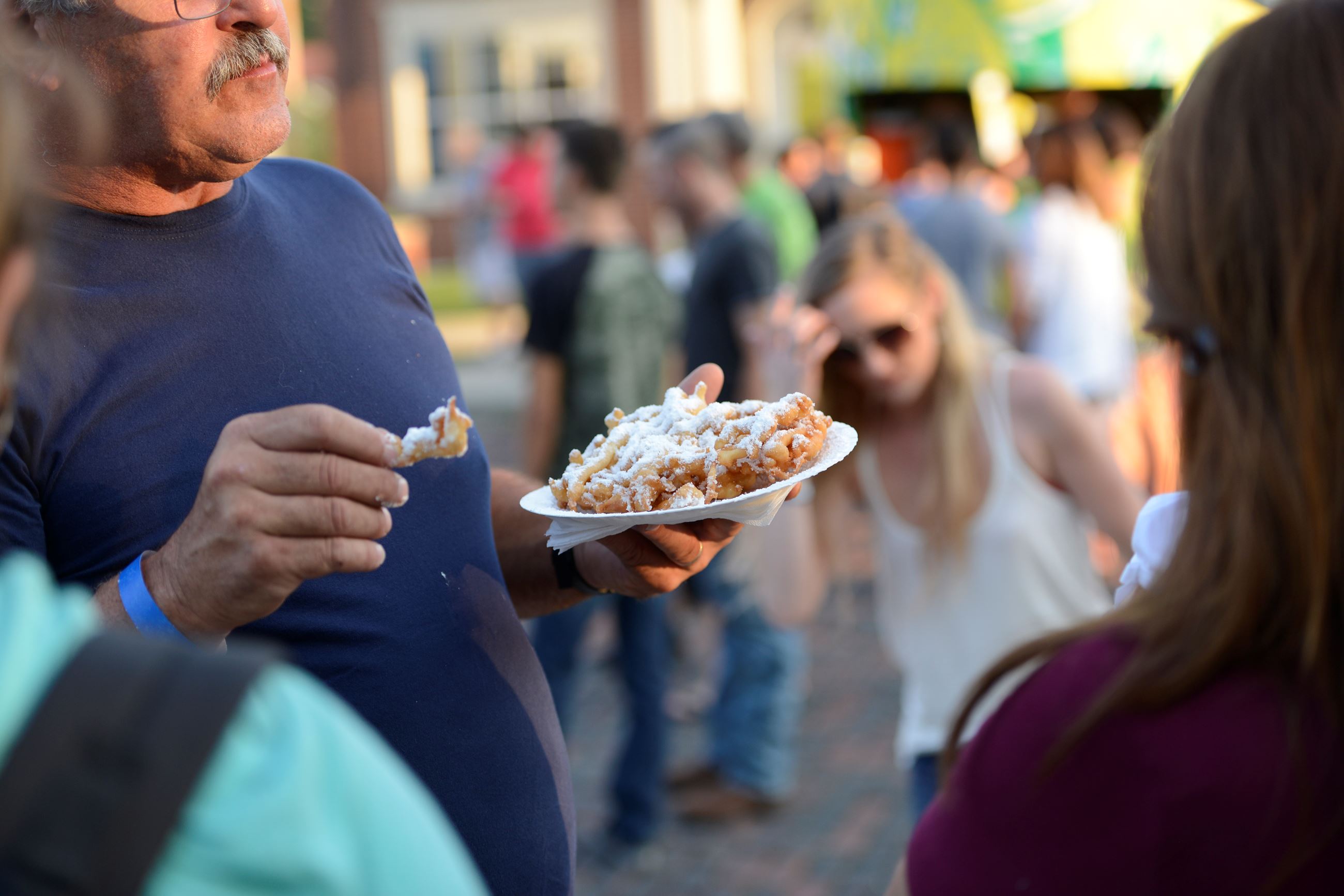 A man holding a funnel cake